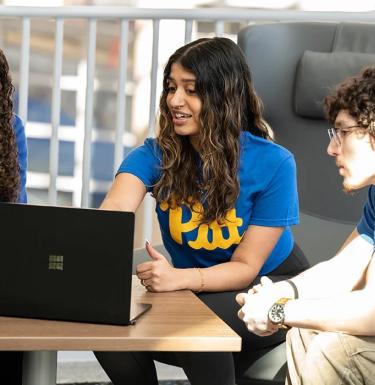 Students gathered around a laptop